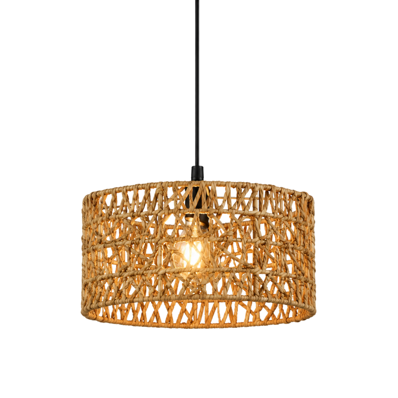 A drum-shaped pendant light with a natural woven rattan or wicker shade, suspended by a black cord with a visible warm light bulb inside, set against a plain white background.